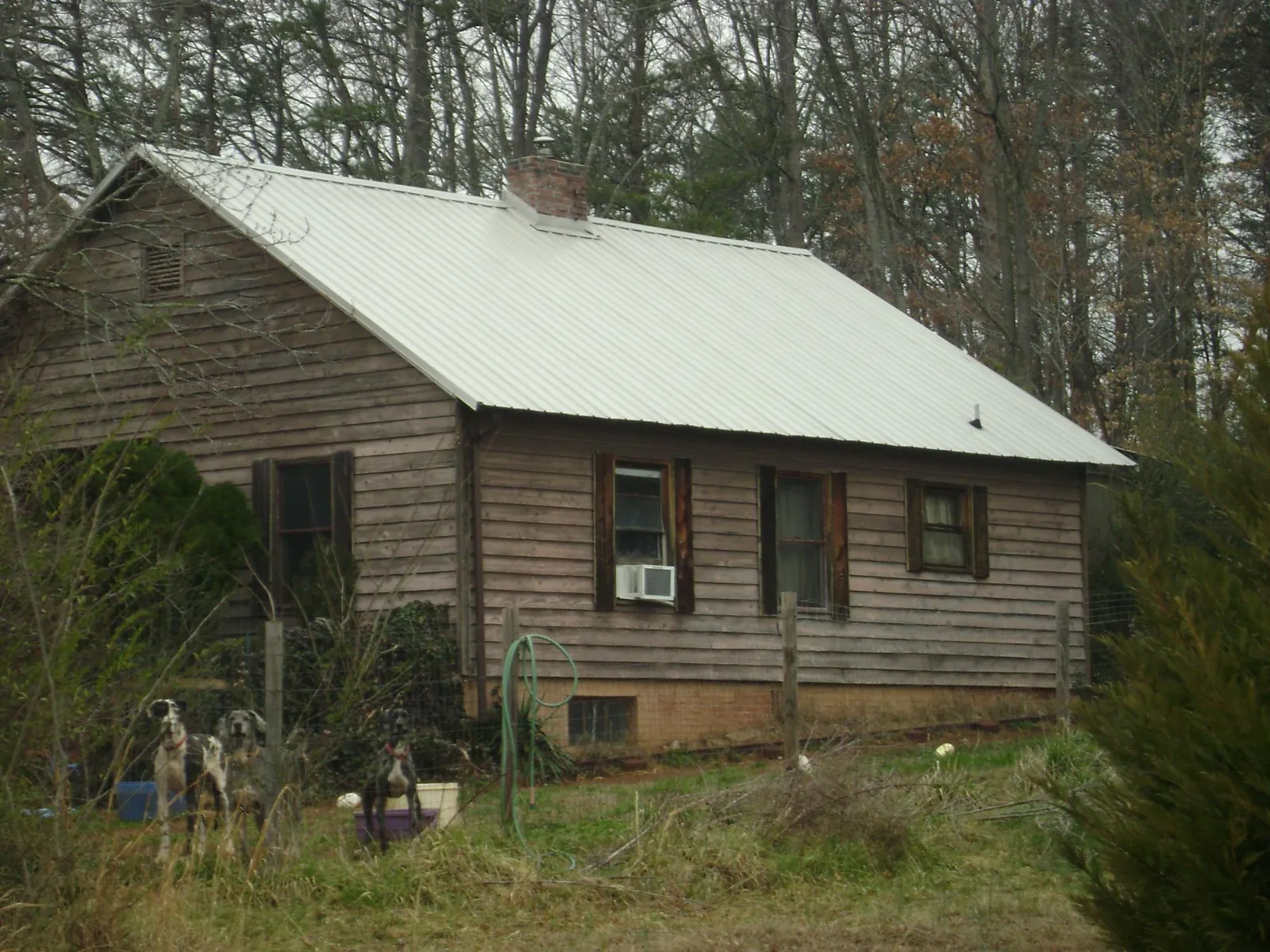 White metal roof on an old wood sided farmhouse, from a Metal Roof Installation job in Rice
